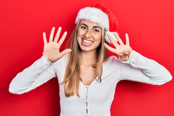 他那戴着圣诞帽的漂亮女人 带着九号手指 面带微笑 自信而快乐 — 图库照片