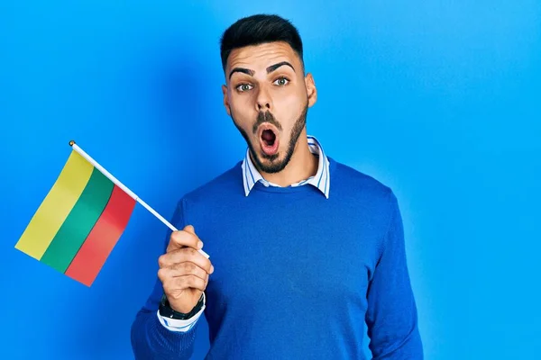Jovem Hispânico Com Barba Segurando Bandeira Lithuania Assustado Espantado Com — Fotografia de Stock