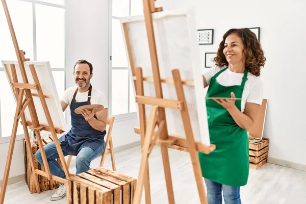 Resim stüdyosunda gülümseyen iki orta yaşlı öğrenci..