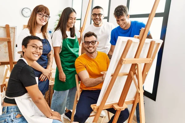 Mutlu gülümseyen ve ortak arayan bir grup insan sanat stüdyosunda..