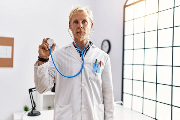 Giovane Uomo Biondo Indossare Uniforme Medico Tenuta Stetoscopio Clinica Pensiero — Foto Stock