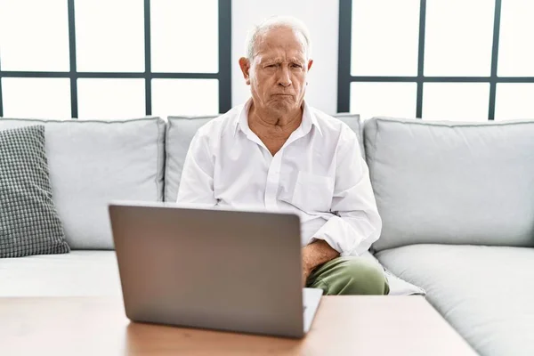 Hombre Mayor Usando Portátil Casa Sentado Sofá Escéptico Nervioso Frunciendo — Foto de Stock