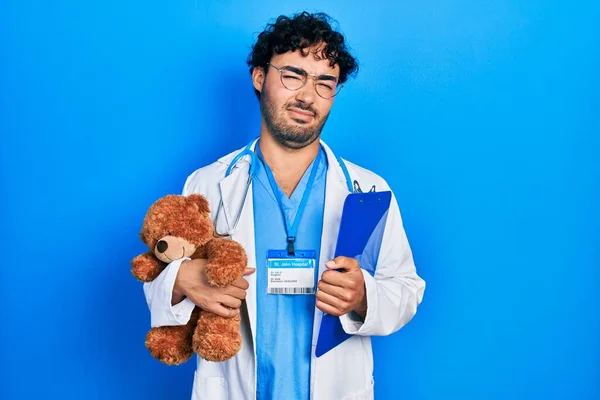 Młody Latynos Mundurze Doktora Trzymający Pluszowego Misia Schowek Bez Pojęcia — Zdjęcie stockowe