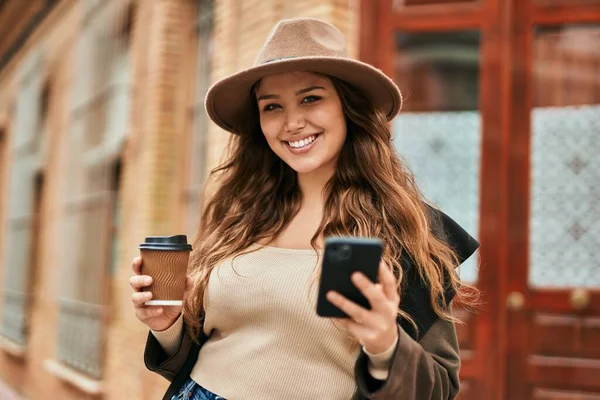 Genç İspanyol turist kadın akıllı telefon kullanıyor ve şehirde kahve içiyor..