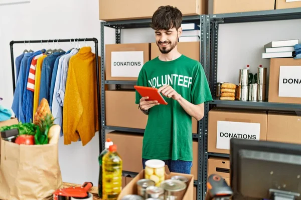Jonge Spaanse Man Vrijwilligersuniform Met Touchpad Een Liefdadigheidscentrum — Stockfoto