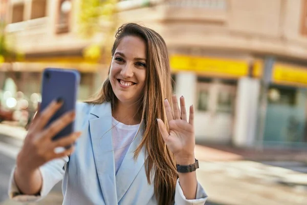 在城市里 年轻的金发女商人用智能手机打视频电话 — 图库照片