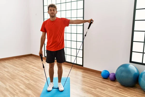 Giovane Uomo Ispanico Sorridente Allenamento Fiducioso Utilizzando Elastico Centro Sportivo — Foto Stock