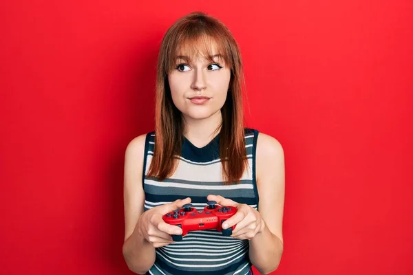 Ruiva Jovem Mulher Jogando Vídeo Game Segurando Controlador Sorrindo Olhando — Fotografia de Stock