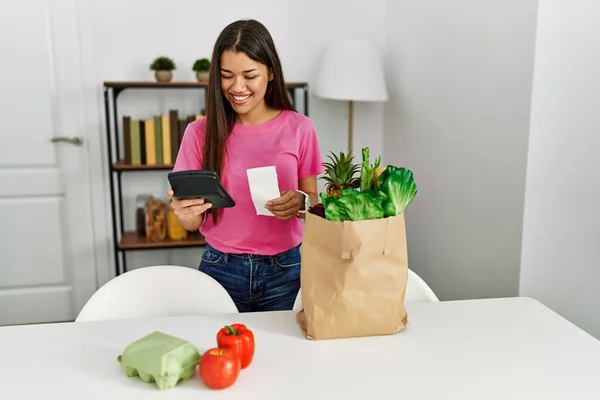 Joven Latina Calculando Premio Bolsa Comestibles Casa — Foto de Stock