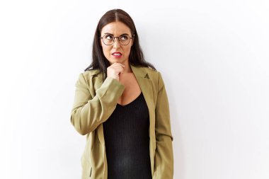 Soyutlanmış arka planda duran esmer kadın bir soru hakkında endişeli ve gergin bir şekilde düşünüyor. 