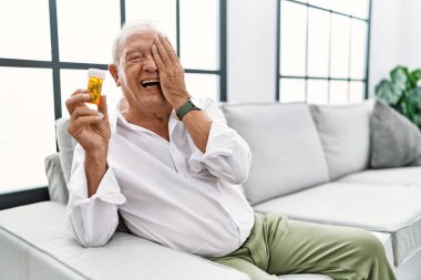 Son sınıf öğrencisi elinde haplarla bir gözünü eliyle kapatıyor, yüzünde kendine güvenen bir gülümseme ve şaşırtıcı bir duygu var.. 