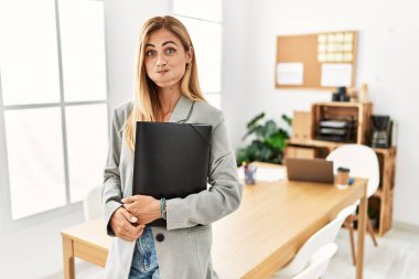 Ofisteki sarışın iş kadını komik suratıyla yanaklarını şişiriyor. Havayla şişmiş ağız, çılgın bir ifade.. 