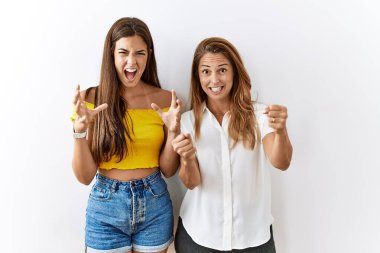 Anne ve kızı birlikte izole edilmiş arka planda öfkeli ve kızgın bir şekilde ayakta duruyor öfkeyle bağırırken yumruklar havada uçuşuyor. öfke ve agresif konsept. 