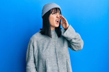 Genç İspanyol kadın yün kazak ve kışlık şapka giyip el ele tutuşarak bağırıyor ve çığlık atıyordu. iletişim konsepti. 