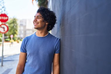 Sokakta kendinden emin gülümseyen İspanyol genç adam.