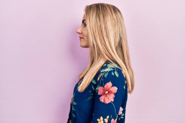 Kafkasyalı genç bir kadın günlük giysiler giyiyor, rahat bir görünüm takınıyor, doğal bir yüz ifadesi ve kendine güvenen bir gülümsemeyle poz veriyor.. 