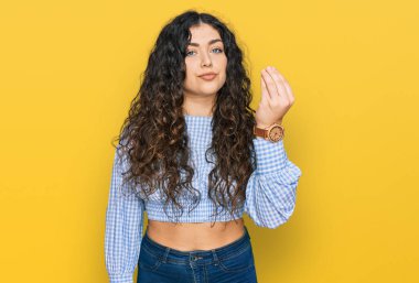 Gündelik kıyafetler giyen genç İspanyol kız İtalyan jesti yapıyor, elleri ve parmakları ile kendinden emin ifade ediyor. 