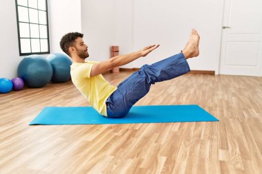 Genç Arap sporcu adam spor merkezinde yoga antrenmanına konsantre ol..