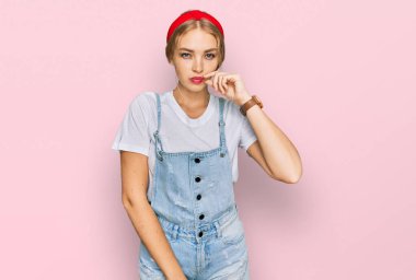 Gündelik kıyafetler giyen genç beyaz kız ağzı ve dudakları parmaklarıyla fermuar gibi kapalı. gizli ve sessiz, tabu konuşması 