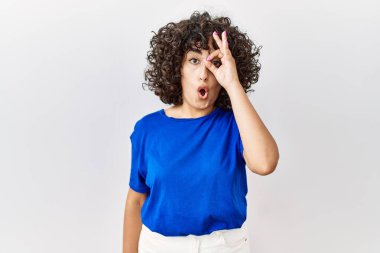 Ortadoğulu genç bir kadın tecrit edilmiş arka planda duruyor. Şaşırmış yüz ifadesiyle şaşırmış, parmaklarından bakan gözlerle hareket ediyor. İnançsız ifade. 