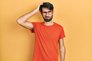 Gündelik kıyafet ve gözlük takan genç İspanyol adam soru sorup kafasını karıştırıyor. Şüpheyle kararsız, kafa kafaya düşünerek. Düşünceli kavram. 