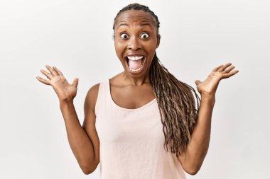 Saçları örgülü siyah bir kadın çılgın ve başarısını kutluyor. Kolları açık, gözleri açık, heyecanlı bir şekilde çığlık atıyor. Kazanan konsept 