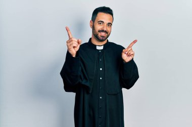 Sakallı, Katolik rahip cübbesi giyen, kendine güvenen, farklı yönleri gösteren yakışıklı İspanyol bir adam. reklam için kopyalama alanı 