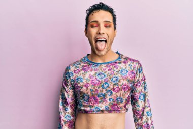 Moda kıyafetleri giymiş yakışıklı bir adam komik bir ifadeyle dilini dışarı çıkartıyor. duygu kavramı. 