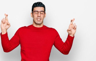 Yakışıklı İspanyol bir adam, günlük kıyafetler ve gözlük takıyor. Umut ve gözlerin kapalı gülümseyerek el sallıyor. Şans ve batıl inançlar. 