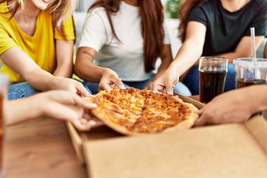 Evde pizza tutan bir grup kadın..