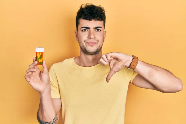Молодий Іспаномовний Чоловік Тримає Таблетки Розлюченим Обличчям Негативний Знак Показує — стокове фото