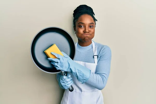 Mujer Afroamericana Con Cabello Trenzado Usando Delantal Sosteniendo Scourer Lavando —  Fotos de Stock
