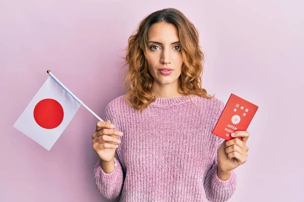 Young Caucasian Woman Holding Japan Flag Passport Relaxed Serious Expression — Stock Photo, Image