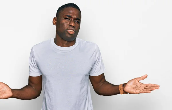 Junger Afrikanisch Amerikanischer Mann Lässigem Weißen Shirt Ahnungslos Und Verwirrt — Stockfoto