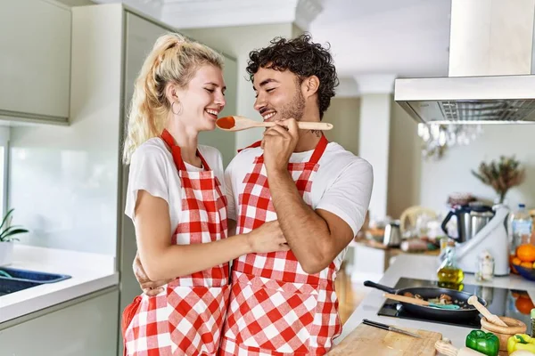 若いカップル笑顔幸せなおいしい食事でキッチン — ストック写真