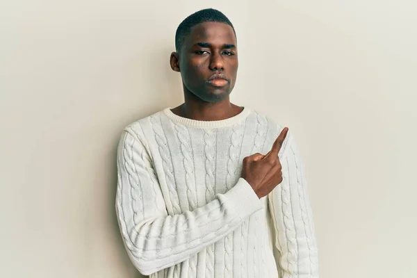 深刻で穏やかな顔を示す側に手指で指すカジュアルな服を着て若いアフリカ系アメリカ人男性 — ストック写真