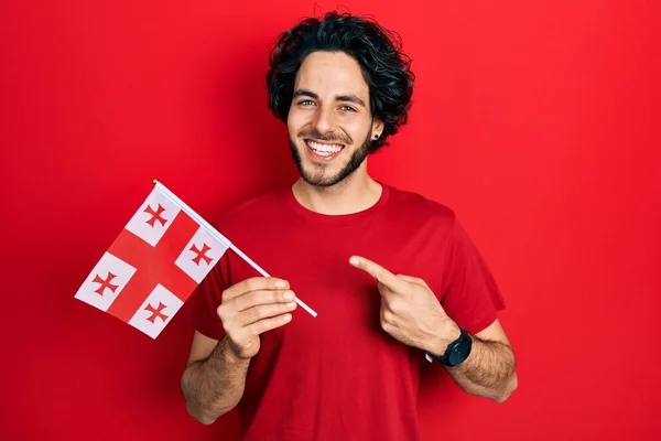 Bonito Hispânico Homem Segurando Bandeira Georgia Sorrindo Feliz Apontando Com — Fotografia de Stock