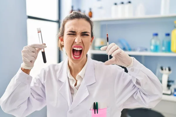 血液サンプルを保持している科学研究所で働く若い女性は怒りで怒りと怒りを叫び フラストレーションと激怒叫びます 怒りと攻撃的な考え方 — ストック写真