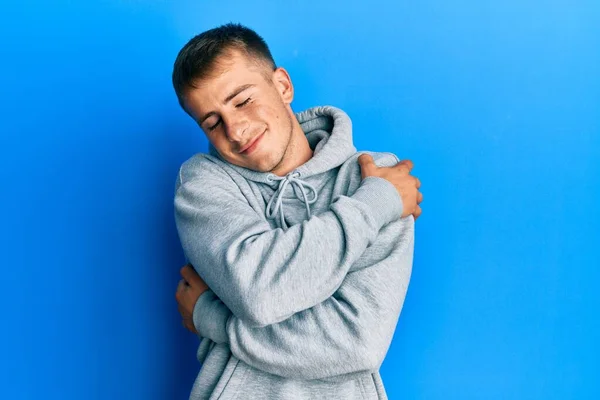 Joven Hombre Caucásico Con Sudadera Casual Abrazándose Feliz Positivo Sonriendo — Foto de Stock