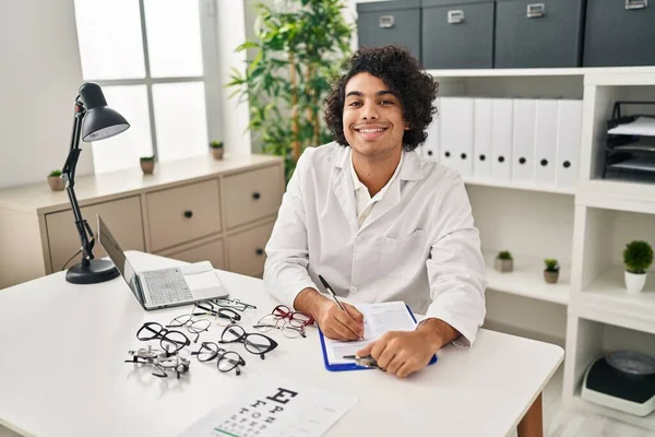 Jonge Spaanse Man Opticien Schrijft Klembord Kliniek — Stockfoto