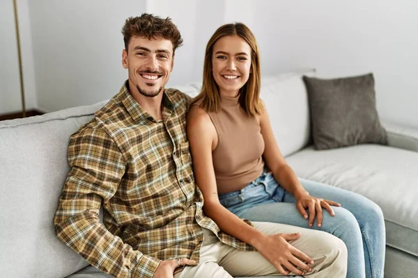 Jovem Casal Hispânico Sorrindo Feliz Abraçando Sentado Sofá Casa — Fotografia de Stock