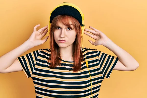 問題のために動揺を眉をひそめ ヘッドフォン懐疑的かつ神経を使用して音楽を聞いて若い女性を再ヘッド 否定的な人 — ストック写真