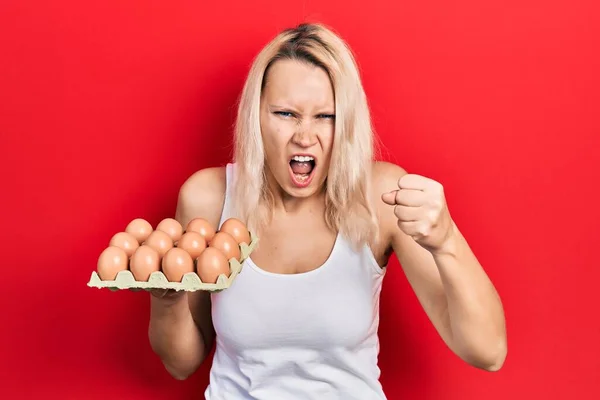Όμορφη Καυκάσια Ξανθιά Γυναίκα Κρατώντας Δίσκο Φρέσκα Αυγά Ενοχλημένα Και — Φωτογραφία Αρχείου
