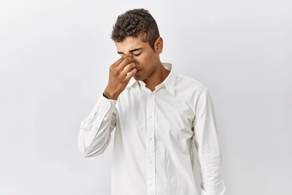 若いハンサムなヒスパニック系の男性が孤立した背景に立って疲れ鼻をこすり 目の疲労や頭痛を感じている ストレスとフラストレーションの概念 — ストック写真