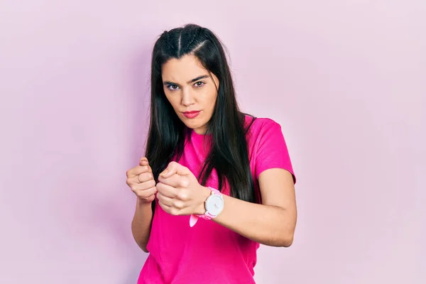 若いヒスパニック系の女の子のカジュアルなピンクのTシャツを着て拳の防衛ジェスチャーで戦うために準備ができて 怒って動揺顔 問題を恐れて — ストック写真