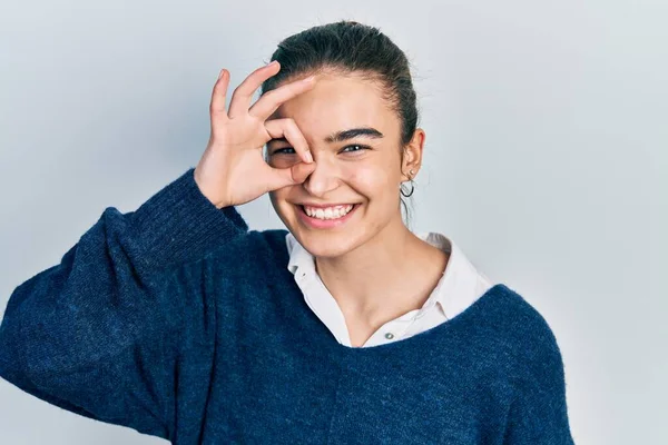 Kafkasyalı genç bir kız günlük kıyafetler giyiyor. El hareketleriyle gülümsüyor ve mutlu yüzüyle parmaklarının arasından bakıyor.. 