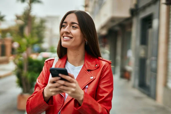 若いヒスパニック系の女性は 市内でスマートフォンを使用して幸せな笑顔 — ストック写真