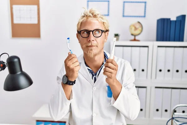 Jonge Blonde Man Werkt Bij Tandarts Kliniek Met Elektrische Tandenborstel — Stockfoto