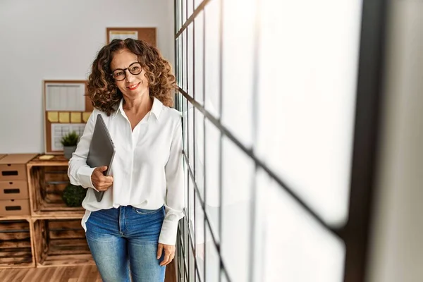 Mujer Hispana Mediana Edad Sonriendo Confiada Sosteniendo Portapapeles Oficina —  Fotos de Stock