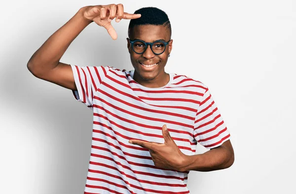 Joven Hombre Afroamericano Vistiendo Camiseta Casual Gafas Sonrientes Haciendo Montura —  Fotos de Stock